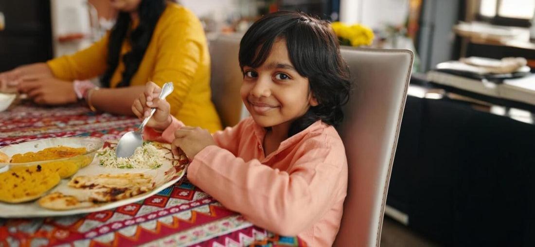 Boy smiling over a home-cooked vegetarian thali